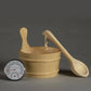 Wooden bucket with ladle and thermometer on a dark background