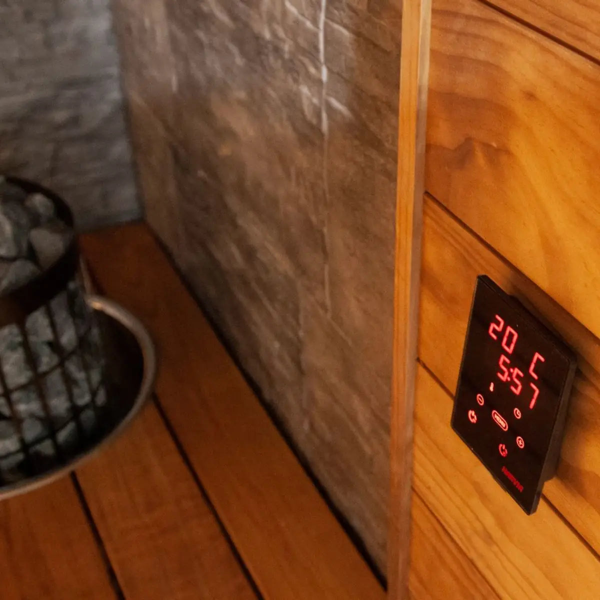 Digital thermometer on a wooden sauna wall showing temperature and time by Finnish Sauna Builders