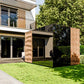 Modern house exterior with a black cube-like structure in the garden